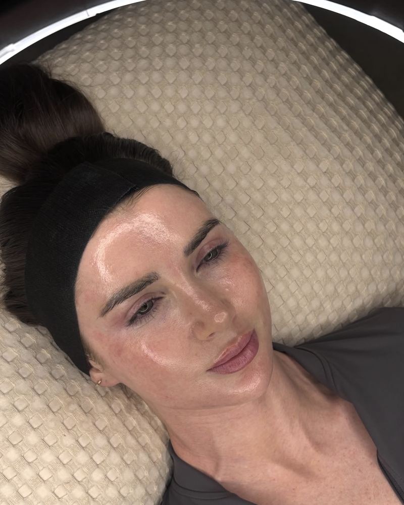 A client in a black headband lying back on the treatment couch at Glow By Yaz, Bletchley